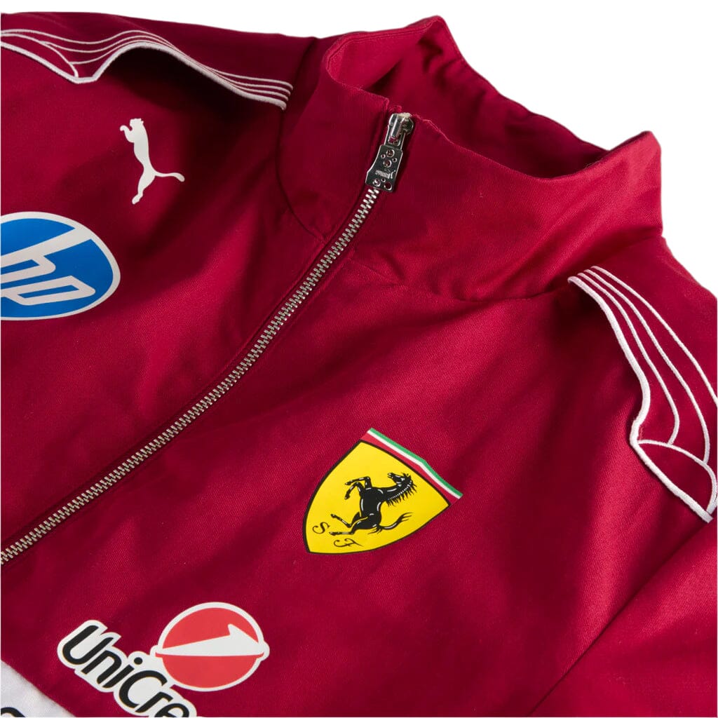 Close-up red racing jacket with metallic zipper, Scuderia Ferrari crest, and Puma logo