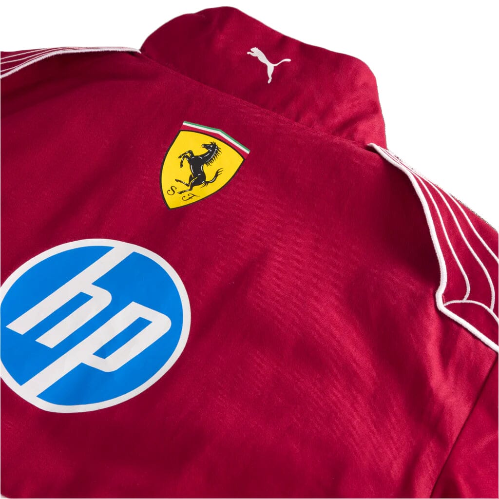 Red racing jacket close-up with Ferrari crest, blue HP logo, and shoulder stripe detailing